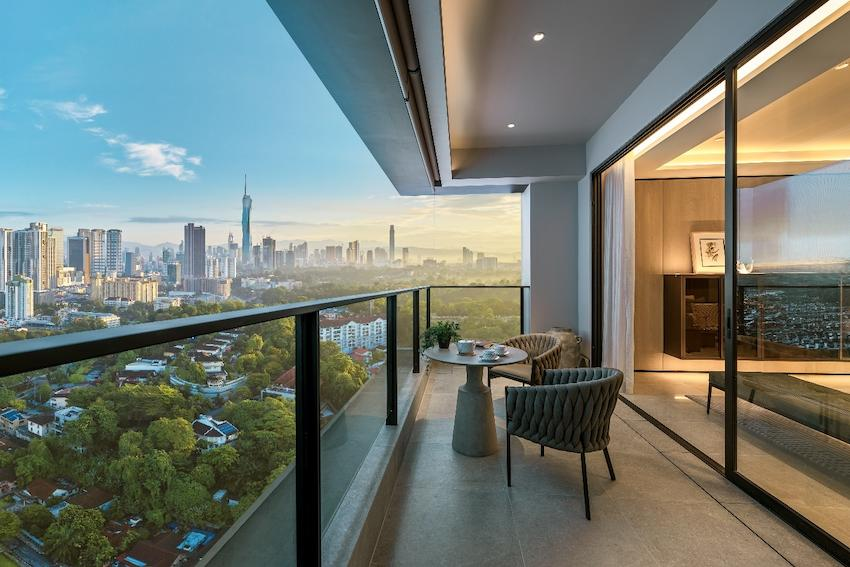 A modern Kuala Lumpur apartment balcony overlooking a green city skyline, representing comfortable affordable life abroad